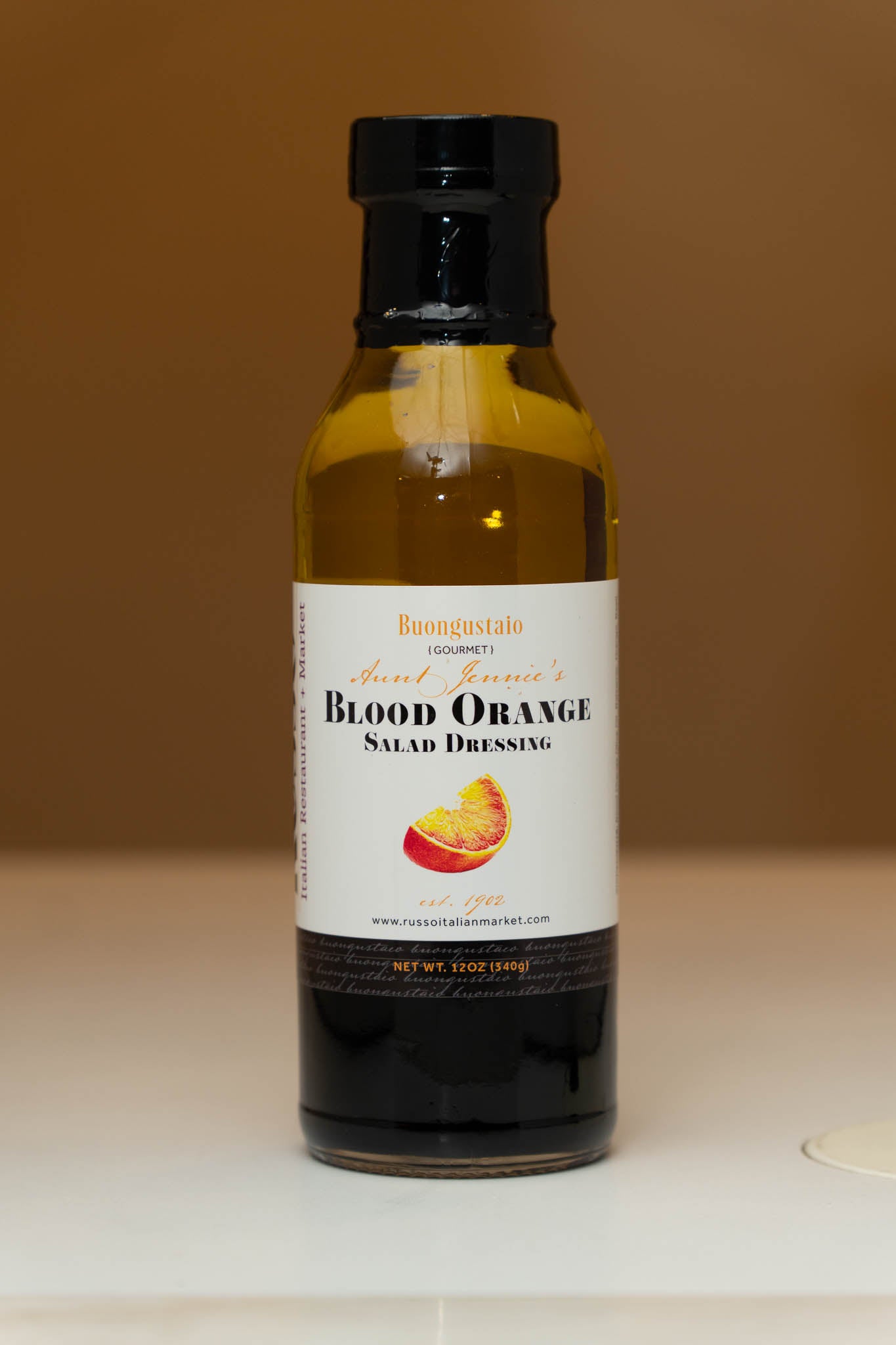 Bottle of Blood Orange Salad Dressing on a neutral background
