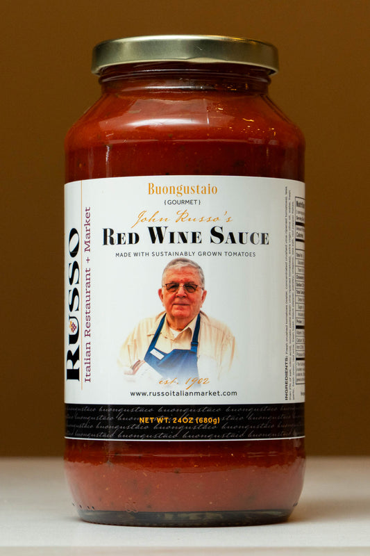 Jar of red wine sauce with a label featuring John Russo on a brown background