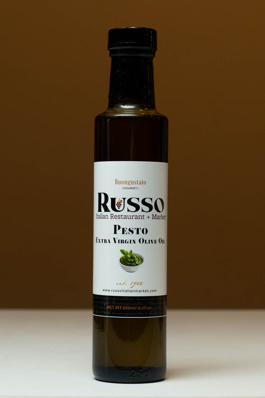 Bottle of Russo Pesto Extra Virgin Olive Oil on a white surface with a brown background