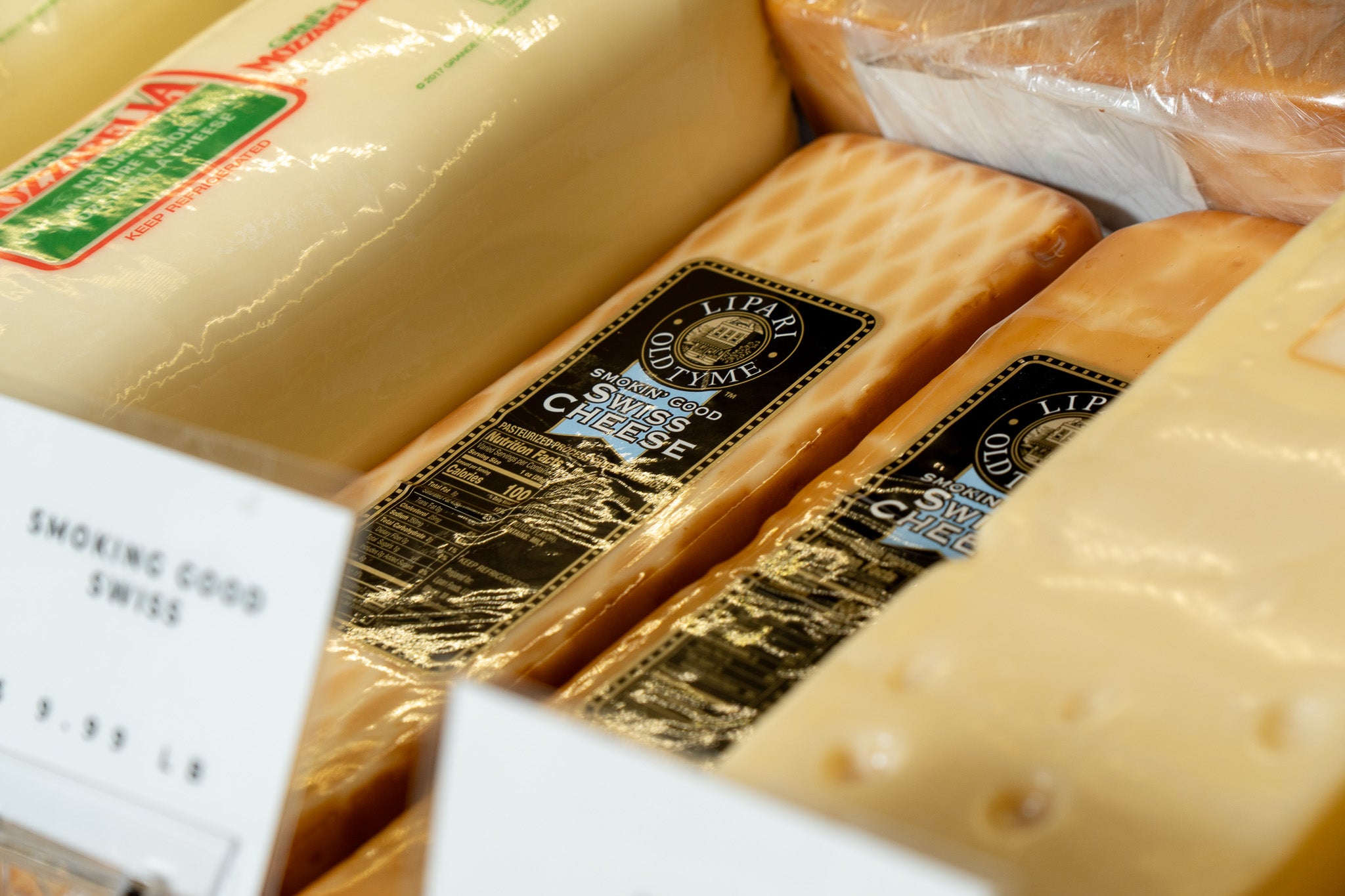 Close-up of various types of cheese with visible branding on a white background