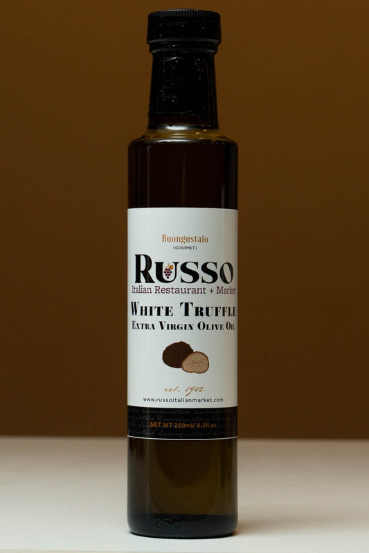 Bottle of Russo White Truffle Extra Virgin Olive Oil on a white surface with a brown background
